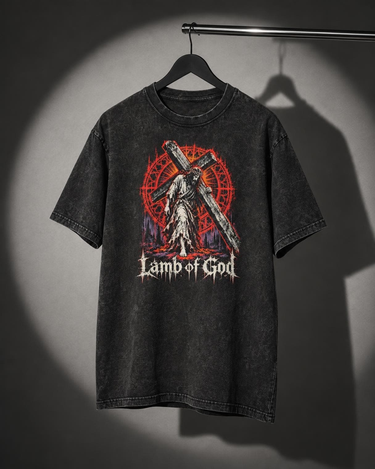 Lamb of God Tee hanging on a rail under a studio spotlight
